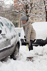 Image showing Independent woman shoveling snow in winter.