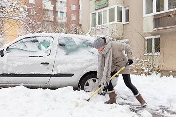 Image showing Independent woman shoveling snow in winter.