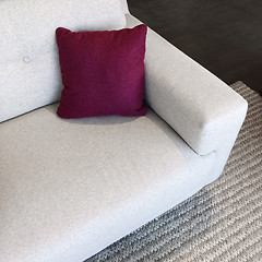 Image showing White sofa with cherry red cushion