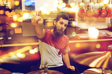 Image showing male musician playing drum kit at music store