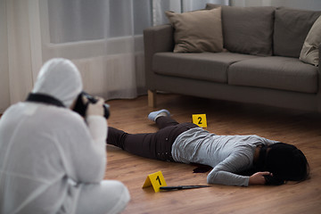 Image showing criminalist photographing dead body at crime scene