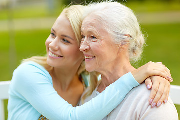 Image showing daughter with senior mother hugging on park bench