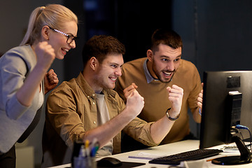 Image showing business team celebrating success at night office