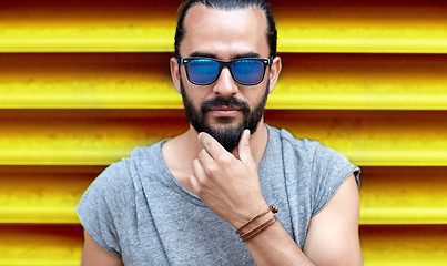 Image showing close up of man in sunglasses touching beard