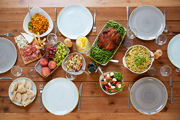 Image showing various food on served wooden table