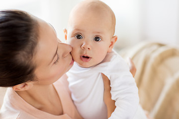 Image showing happy mother kissing little baby boy at home