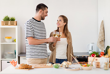 Image showing couple cooking food and drinking wine at home