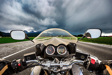 Image showing Biker on a motorcycle hurtling down the road in a lightning stor