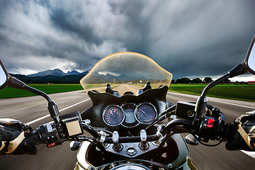 Image showing Biker on a motorcycle hurtling down the road in a lightning stor