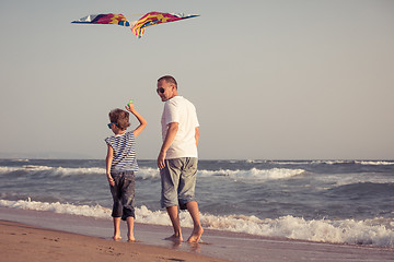 Image showing Father and son playing on the beach at the day time.