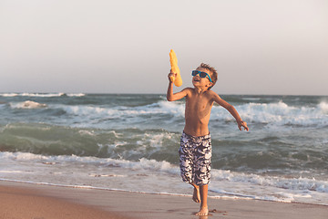 Image showing One happy little boy playing on the beach at the day time.