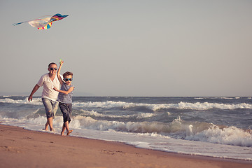 Image showing Father and son playing on the beach at the day time.