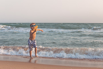 Image showing One happy little boy playing on the beach at the day time.