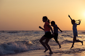 Image showing Happy children playing on the beach at the sunset time.