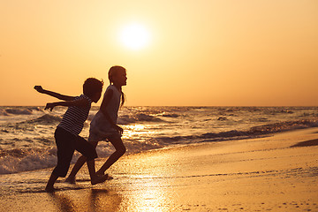 Image showing Happy children playing on the beach at the sunset time.