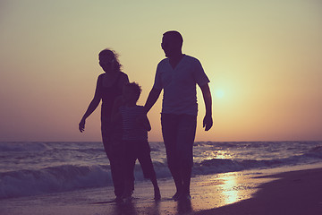 Image showing Father mother and  son  playing on the beach at the sunset time.