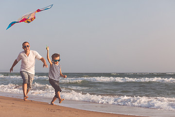 Image showing Father and son playing on the beach at the day time.