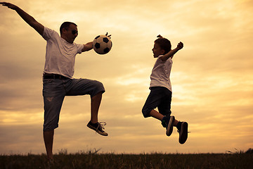 Image showing Father and young little son playing in the field  with soccer ba