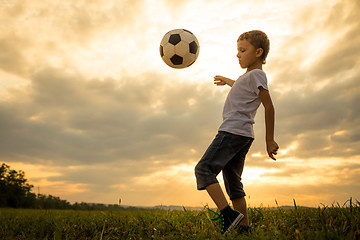 Image showing Young little boy playing in the field  with soccer ball.