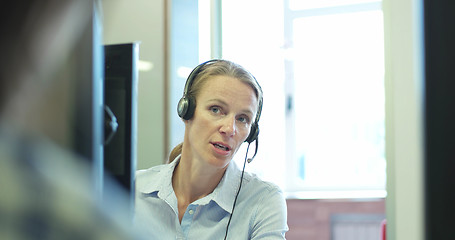 Image showing blonde talking on headset in a call center
