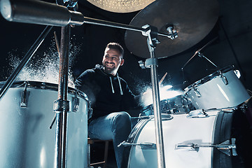 Image showing Drummer rehearsing on drums before rock concert. Man recording music on drum set in studio