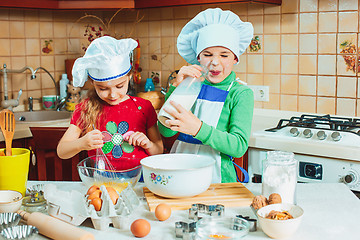 Image showing happy family funny kids are preparing the dough, bake cookies in the kitchen