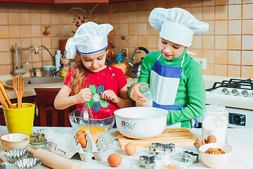 Image showing happy family funny kids are preparing the dough, bake cookies in the kitchen