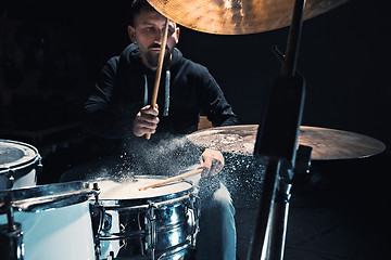 Image showing Drummer rehearsing on drums before rock concert. Man recording music on drum set in studio