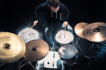 Image showing Drummer rehearsing on drums before rock concert. Man recording music on drum set in studio