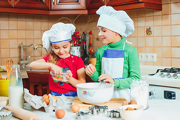 Image showing happy family funny kids are preparing the dough, bake cookies in the kitchen