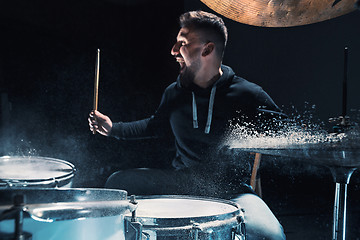 Image showing Drummer rehearsing on drums before rock concert. Man recording music on drum set in studio