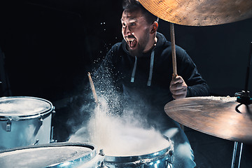 Image showing Drummer rehearsing on drums before rock concert. Man recording music on drum set in studio