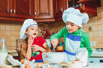 Image showing happy family funny kids are preparing the dough, bake cookies in the kitchen