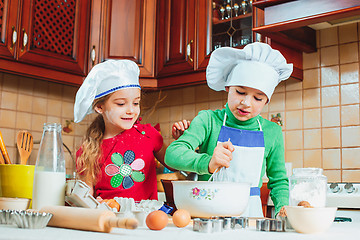 Image showing happy family funny kids are preparing the dough, bake cookies in the kitchen