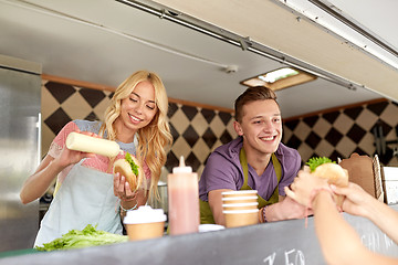 Image showing happy sellers serving customers at food truck