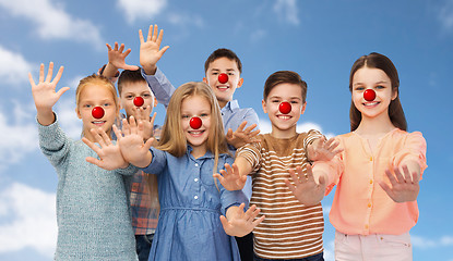 Image showing happy children waving hands at red nose day