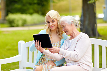 Image showing daughter and senior mother with tablet pc at park