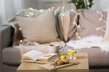 Image showing oat cookies, book, tea and lemon on table at home