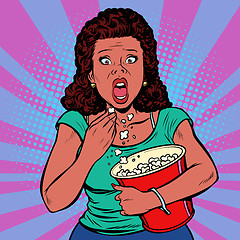 Image showing Woman watching a scary movie and eating popcorn
