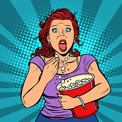 Image showing Woman watching a scary movie and eating popcorn