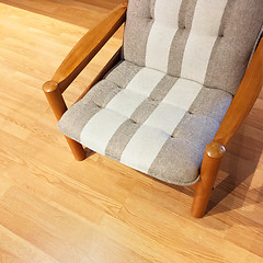 Image showing Comfortable striped armchair on a wooden floor