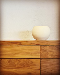 Image showing White ceramic vase on a wooden chest of drawers