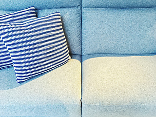 Image showing Striped cushions on a blue textile sofa