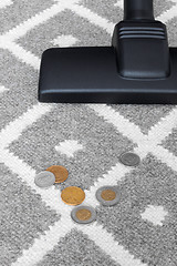 Image showing Vacuum cleaner and coins on gray carpet