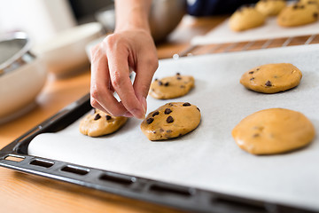 Image showing Adding chocolate chip on cookies