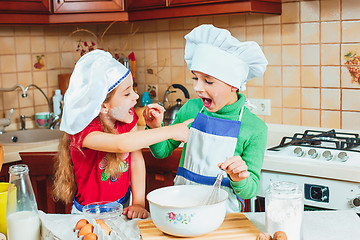 Image showing happy family funny kids are preparing the dough, bake cookies in the kitchen