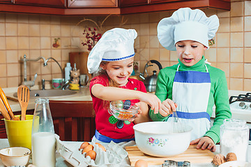 Image showing happy family funny kids are preparing the dough, bake cookies in the kitchen