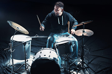 Image showing Drummer rehearsing on drums before rock concert. Man recording music on drum set in studio