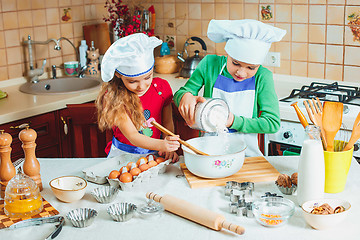 Image showing happy family funny kids are preparing the dough, bake cookies in the kitchen