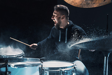 Image showing Drummer rehearsing on drums before rock concert. Man recording music on drum set in studio